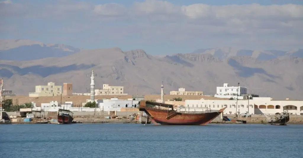 Sur waterfront with a dhow and the mountains behind